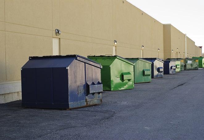 a crowd of dumpsters of all colors and sizes at a construction site in East Prairie